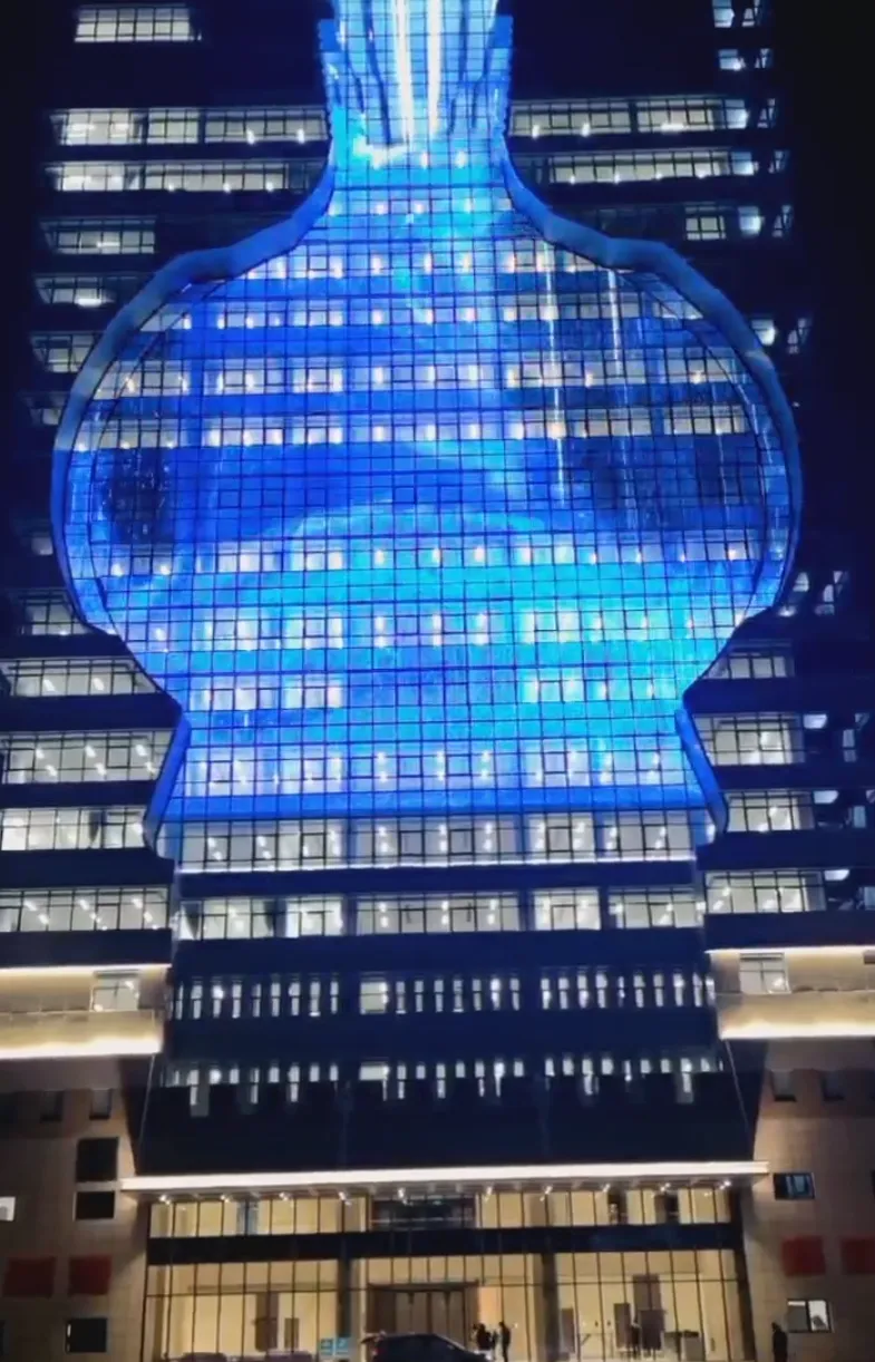 Building facade lit with a blue holographic display at night