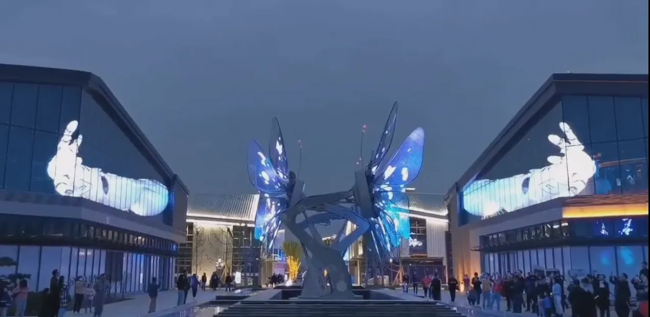 Glass buildings around a plaza showing holographic hand visuals